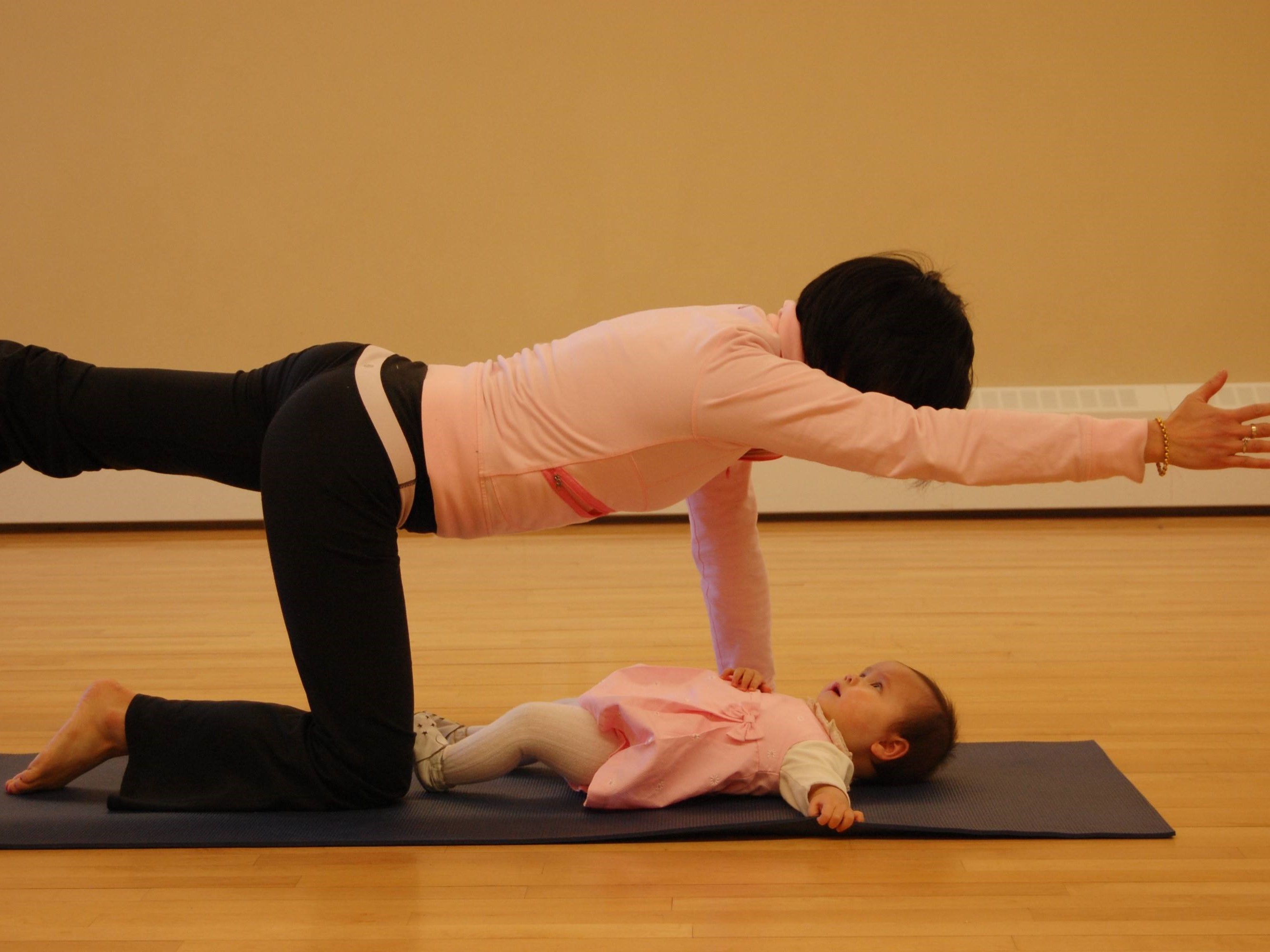 Woman doing yoga with baby